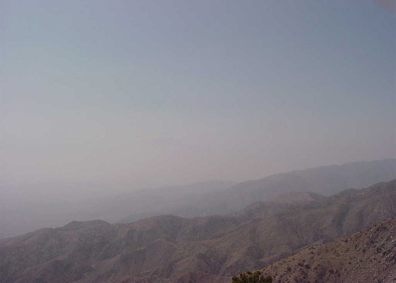 A clear view of a valley and mountains with bright blue skies