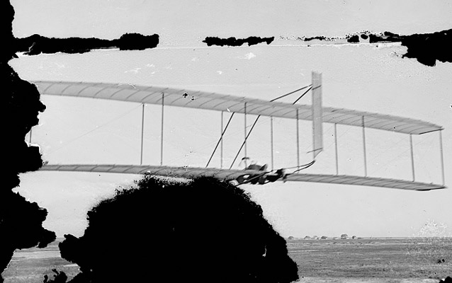 Wilbur gliding with US Lifesaving Station and Weather Station in background- Kitty Hawk, 1902