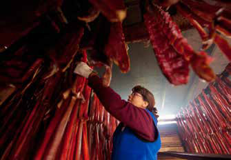 woman in a room with numerous salmon hanging down from the ceiling