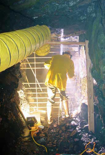 man in a tunnel welding a metal gate