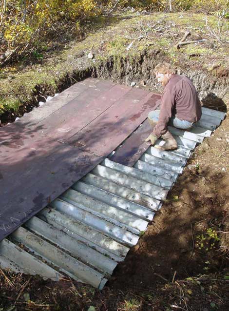 man sitting on a piece of sheet metal