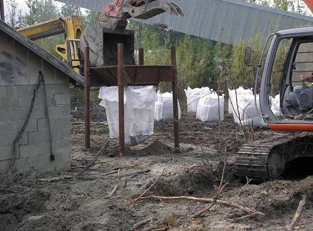 numerous white bags of soil next to heavy equipment