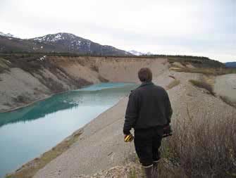 man standing near a rectangular pond