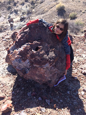 Talia hugs petrified stump at Petrified Forest National Park