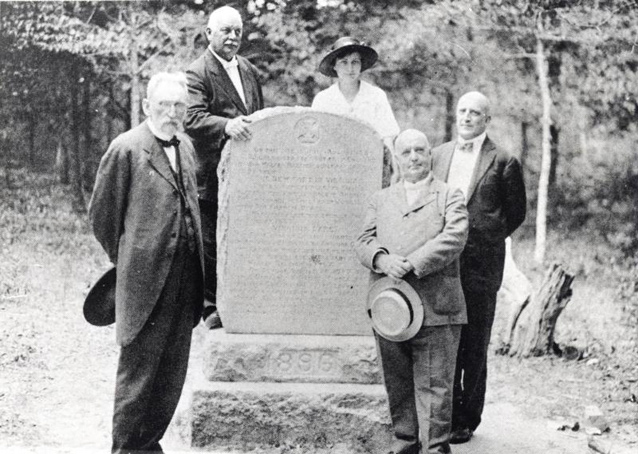 Virginia Dare marker in 1896 with five men and one woman standing around it Virginia Dare marker in 1896 with five men and one woman standing around it