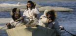 Three Iñupiat men paddling a whaling boat