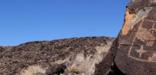 Petroglyphs and volcanic escarpment view from the Mesa Point trail at Boca Negra Canyon.