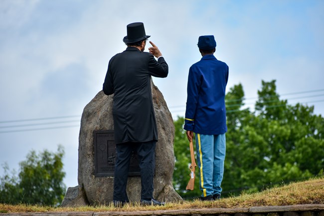 an Abraham Lincoln reenactor talks to a young visitor