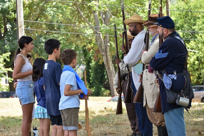 reenactors teach young visitors Civil War infantry drill