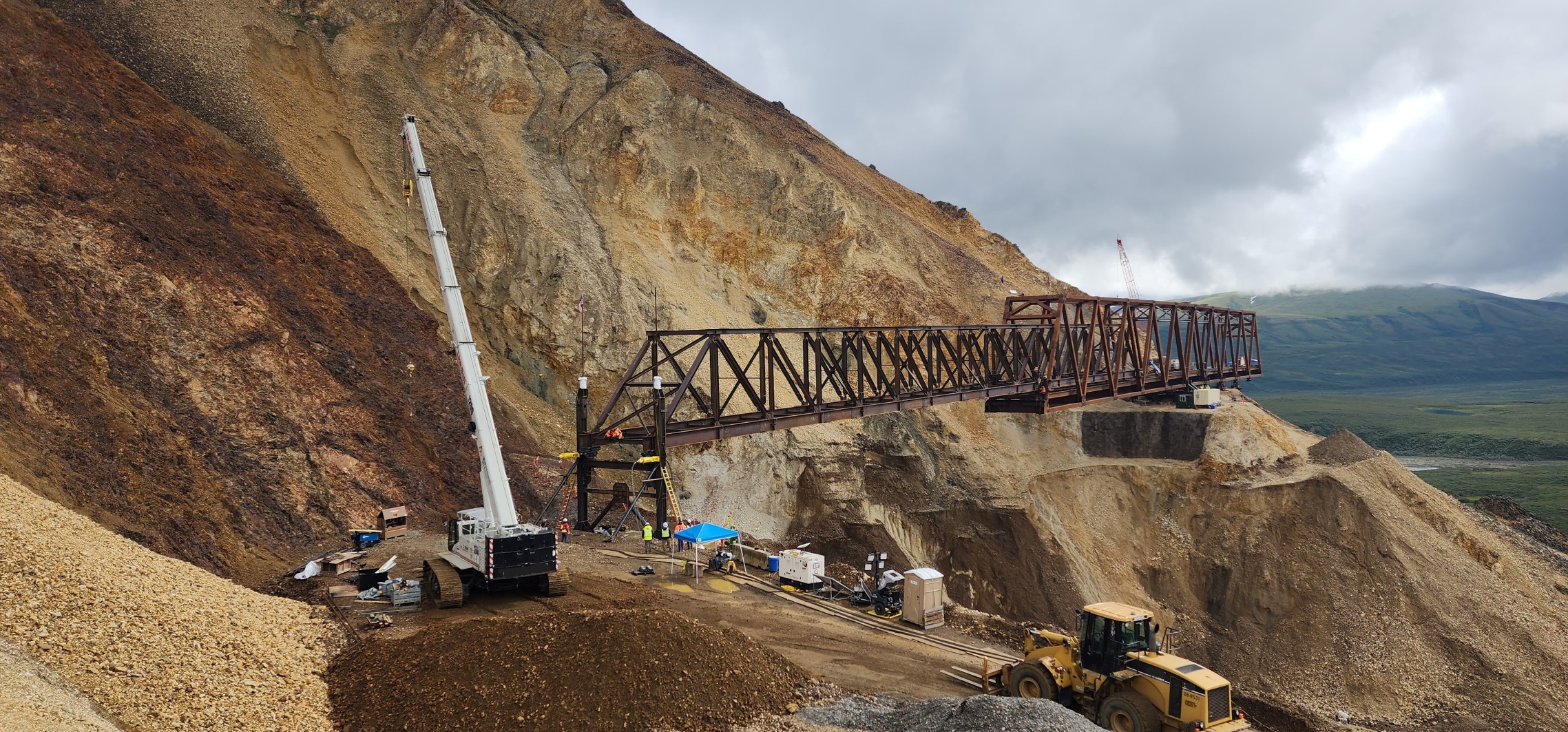 2025 07 27 Launch truss touch down proHNS View from the west side of the launch truss fully spanning the landslide, and the main bridge truss staged on the east side of the slide.