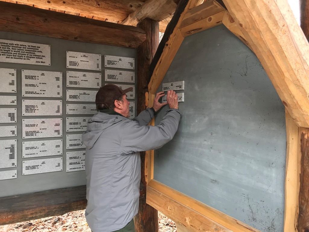 Ranger hangs a plaque on the Climbers Memorial