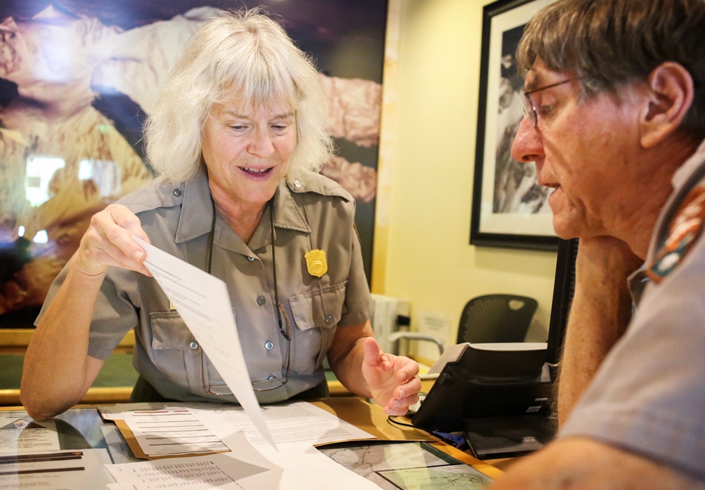 Two rangers looking at the contents of a file folder