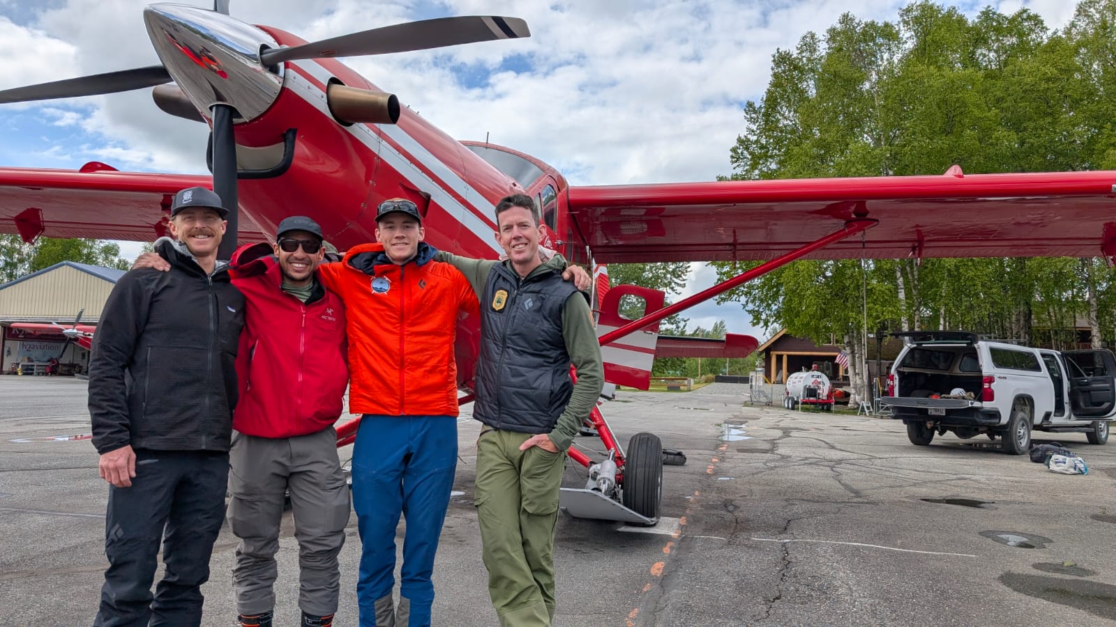 Patrol 5 Team Photo 4 rangers stand arm in arm in front of a red plane