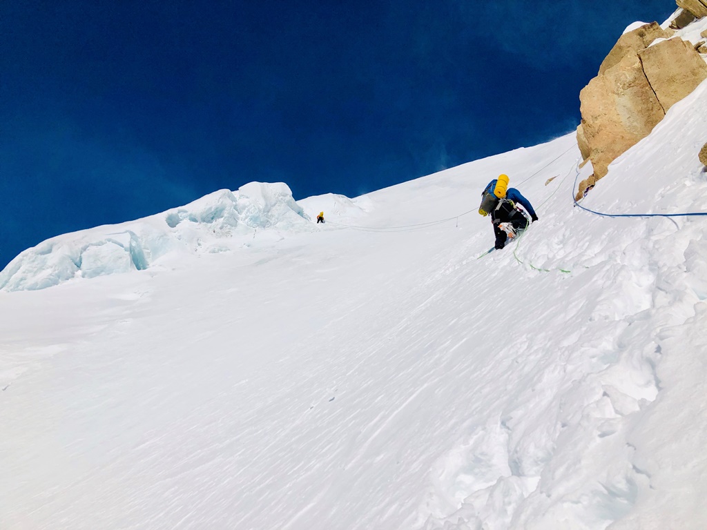 Two roped climbers move upward