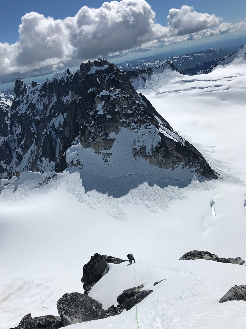 man climbing down a steep, snow-covered mountainside