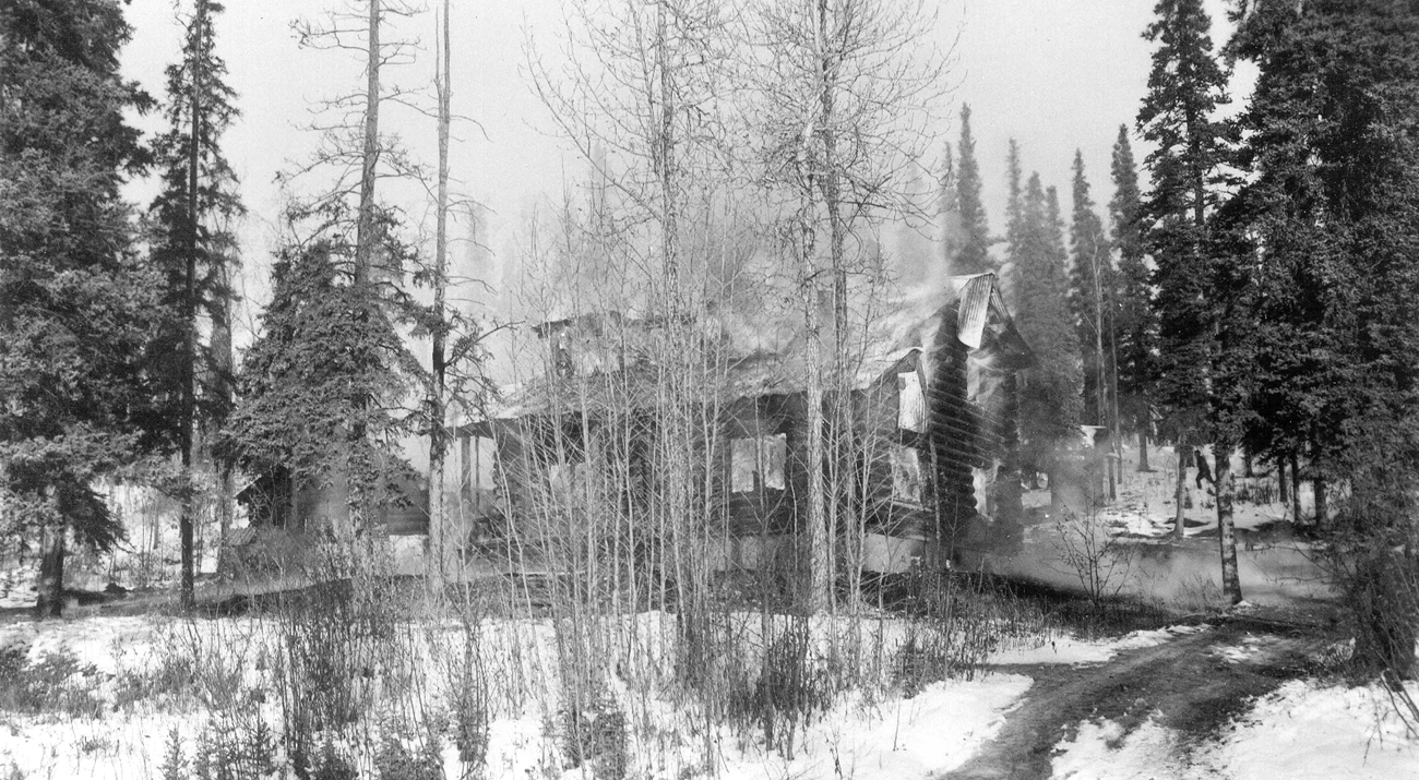DENA 8-27 Supt's house fire 10-23-1939 300dpi black and white image of a partially burnt building in a snowy forest