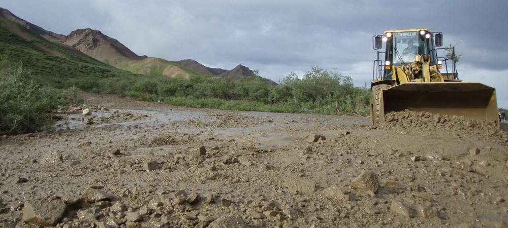 heavy equipment clear a debris flow cause by flooding