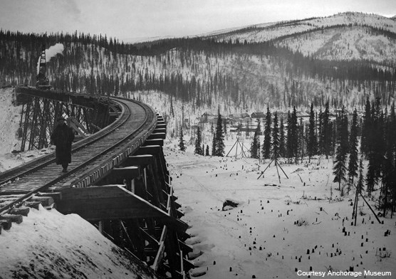 Historic image of person walking along a trail trestle