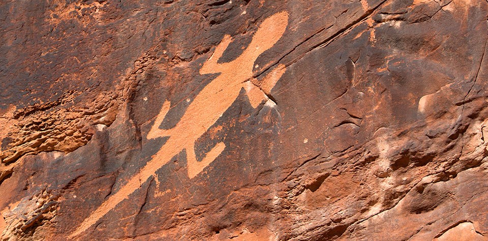 Reddish rock with image of a lizard chipped into the rock.