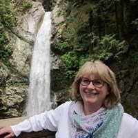 Woman in front of a waterfall.