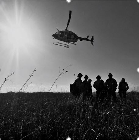 Helicopter flying above fire crew