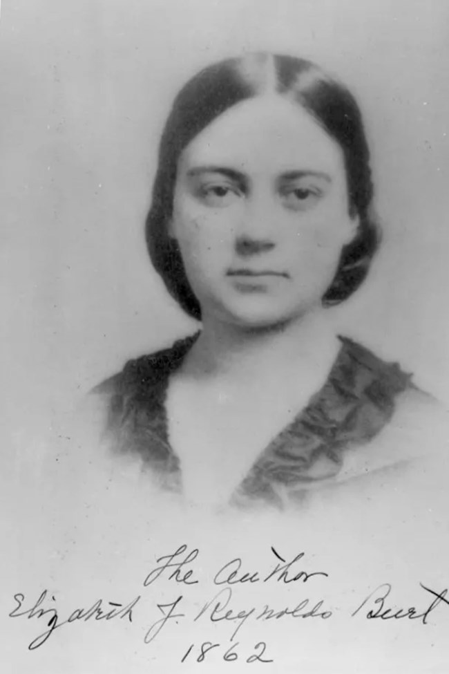An old black and white photo of a woman, showcasing her classic attire and hairstyle.
