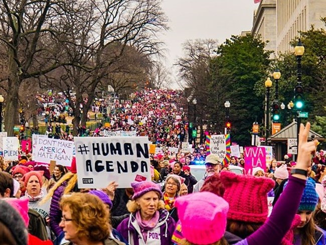 Protest march in Washington DC A large crowd of people march along a Washington DC street with some holding protest signs