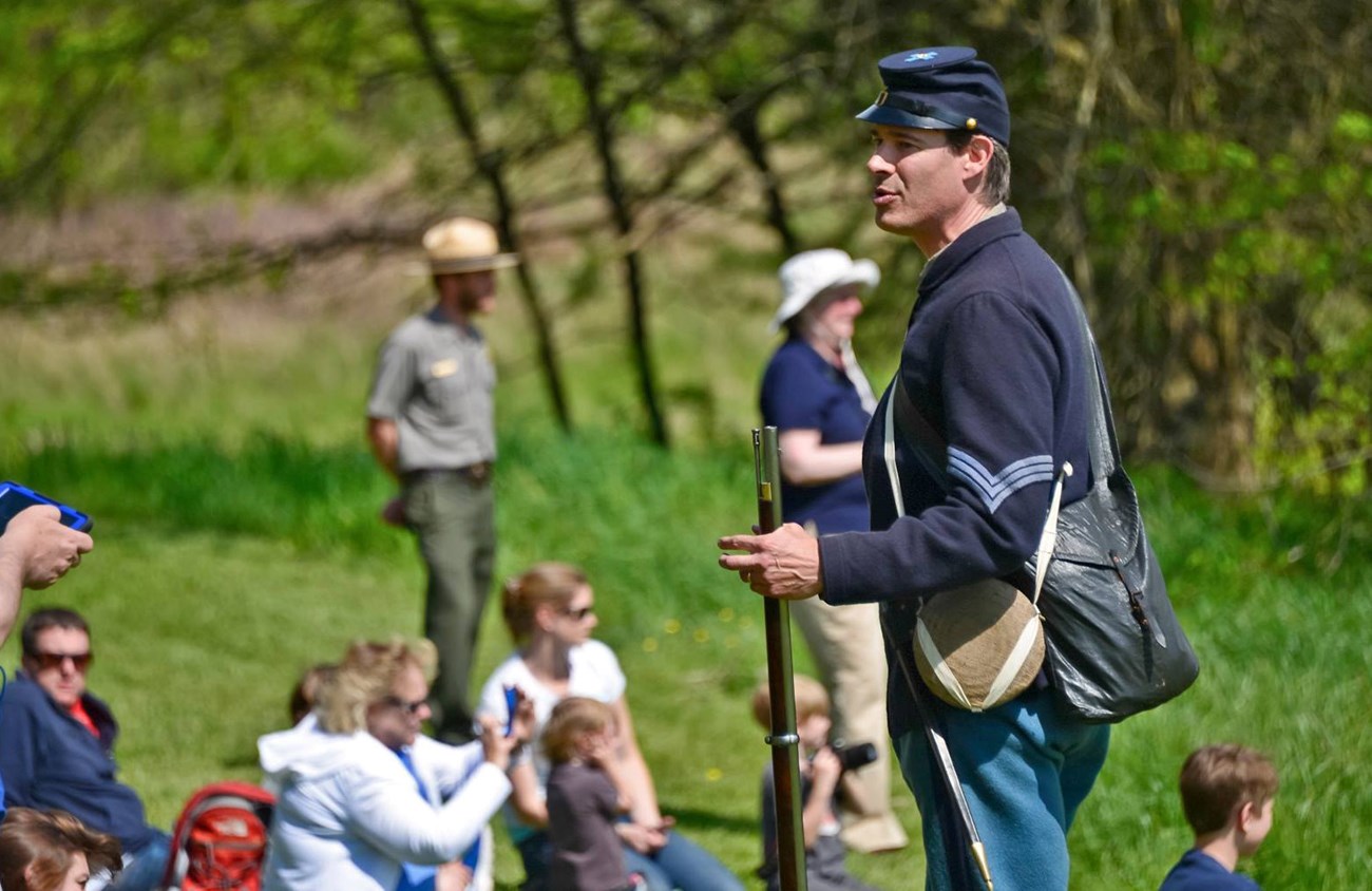 Living Hisotrian dressed as a US Civil War soldier speaks to visitors at the Sunken Road