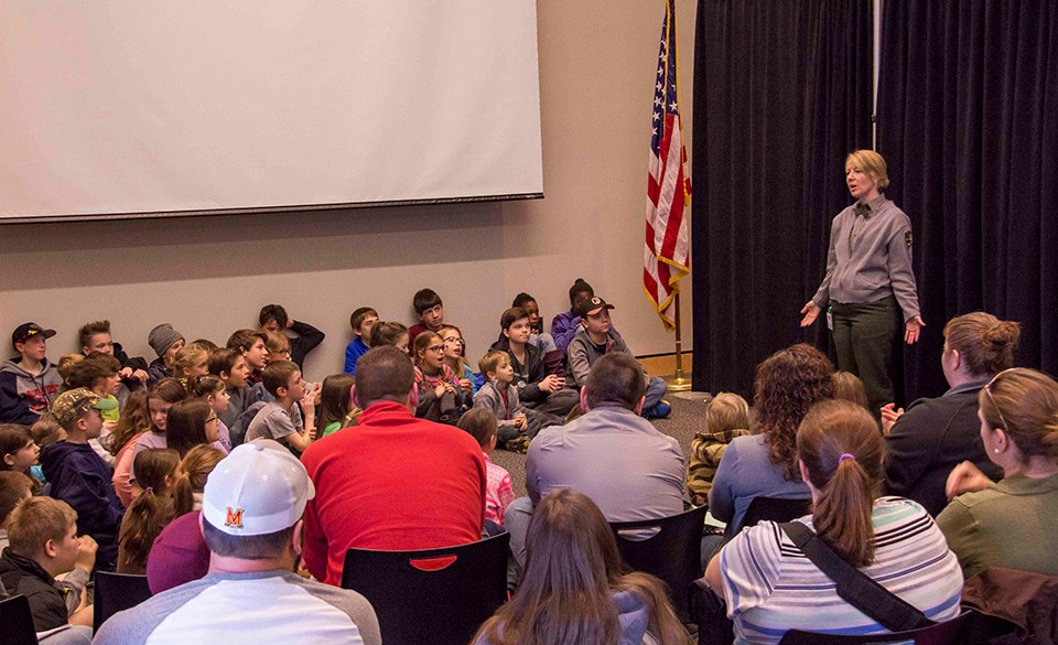 A park ranger talks to students and families during a Homeschool Days event.