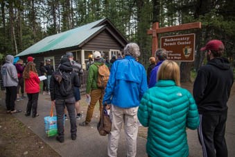 A crowd of people stand in line outside the backcountry permit office at 7:00AM.