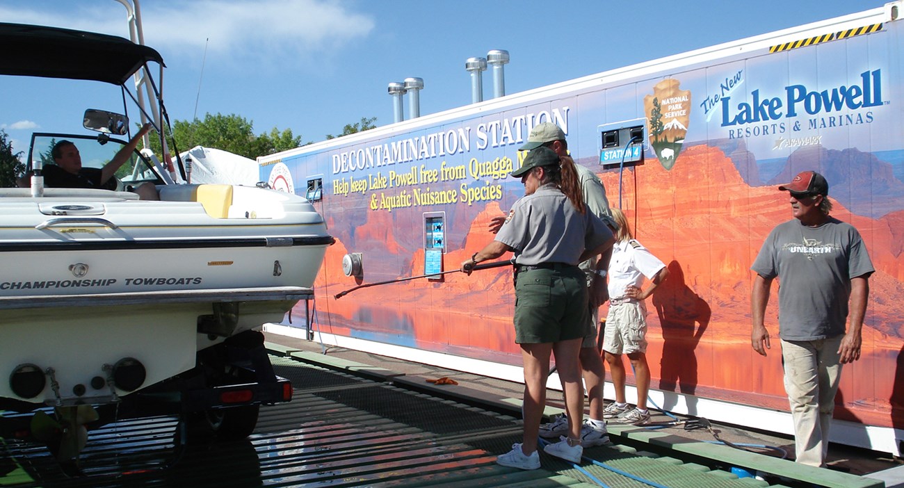 Ranger sprays boat with hot water at Decontamination Station