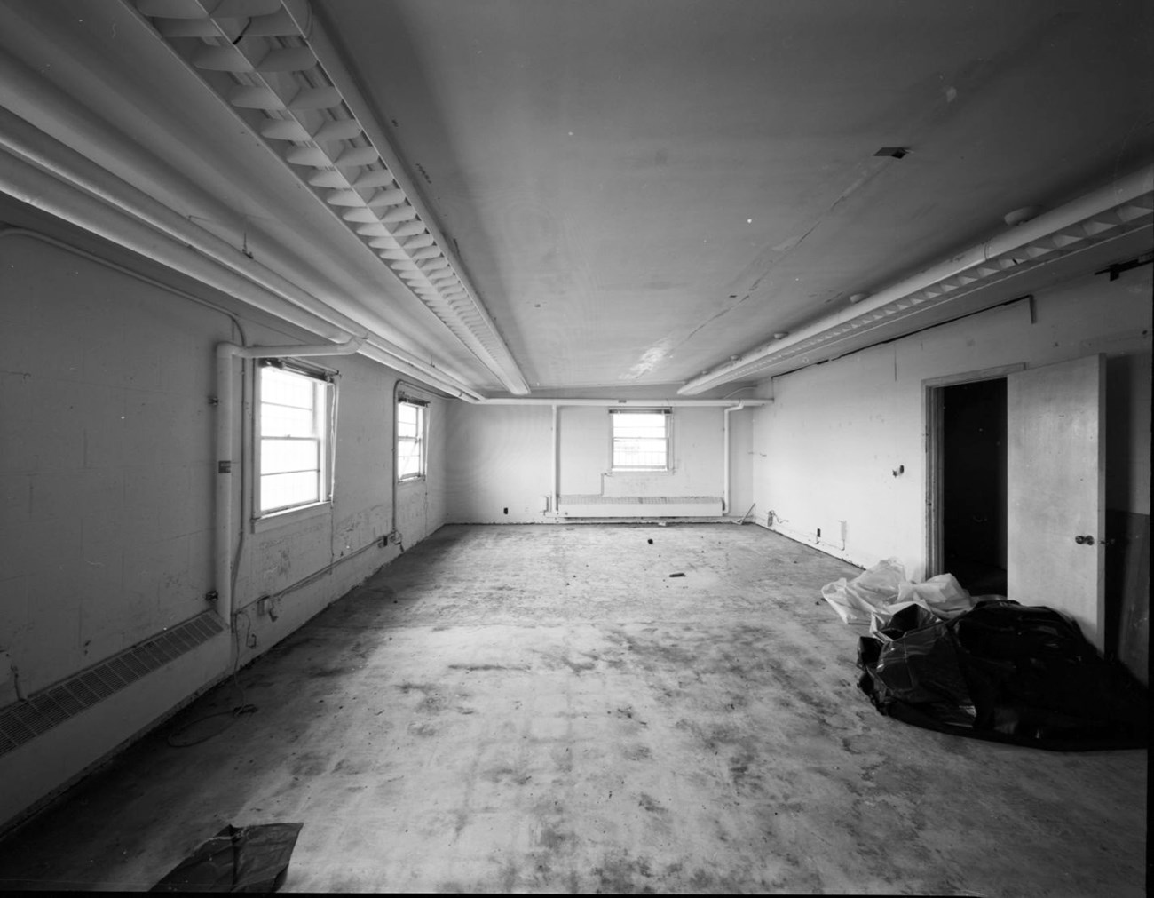 a large empty room with suspended florescent lights