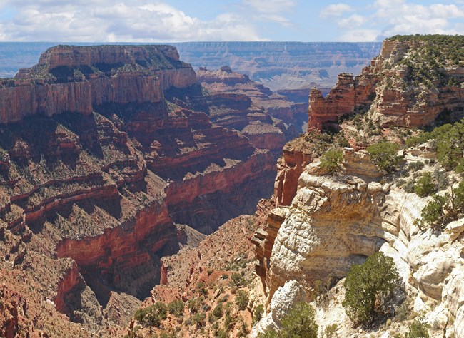 Grand Canyon National Park Sandy colored rock juts out against Grand Canyon landscape.