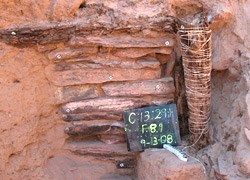 The wooden post next to a masonry wall.