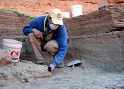 Archeologist excavating one of the units.