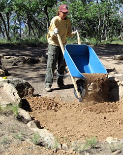 Archeologist backfilling the stucture to stabilize it.