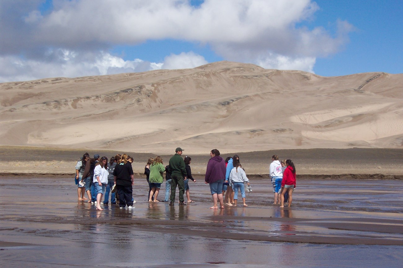 Group of students standing barefoot in Medano Creek