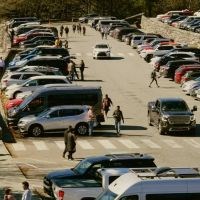 Full parking lot with many people and vehicles