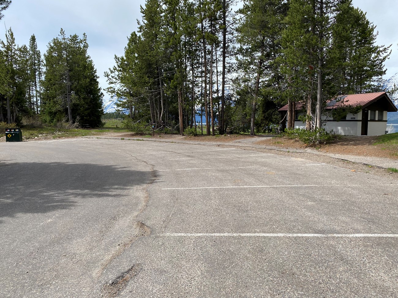 View of parking area with restrooms, bear proof trash cans, and path to ceremony site.