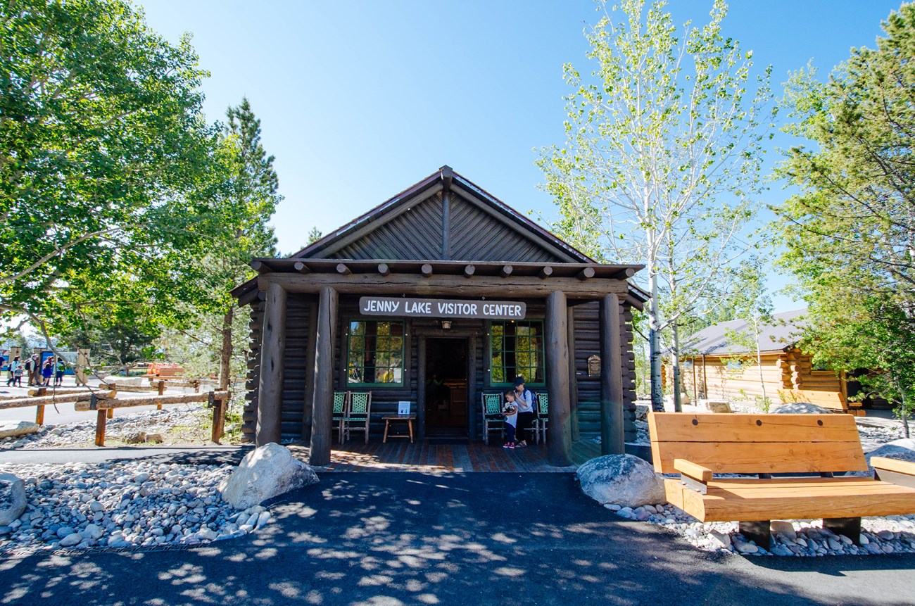 A log cabin with a sign saying "Jenny Lake Visitor Center".