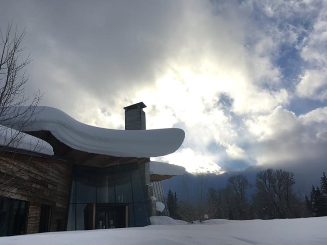 A building with deep snow on the roof.