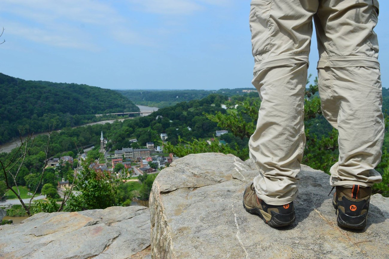 Lower half of hiker standing on cliff edge