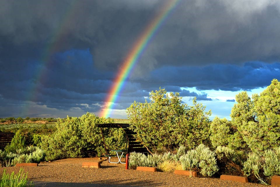 campsite with rainbow and storm clouds in background