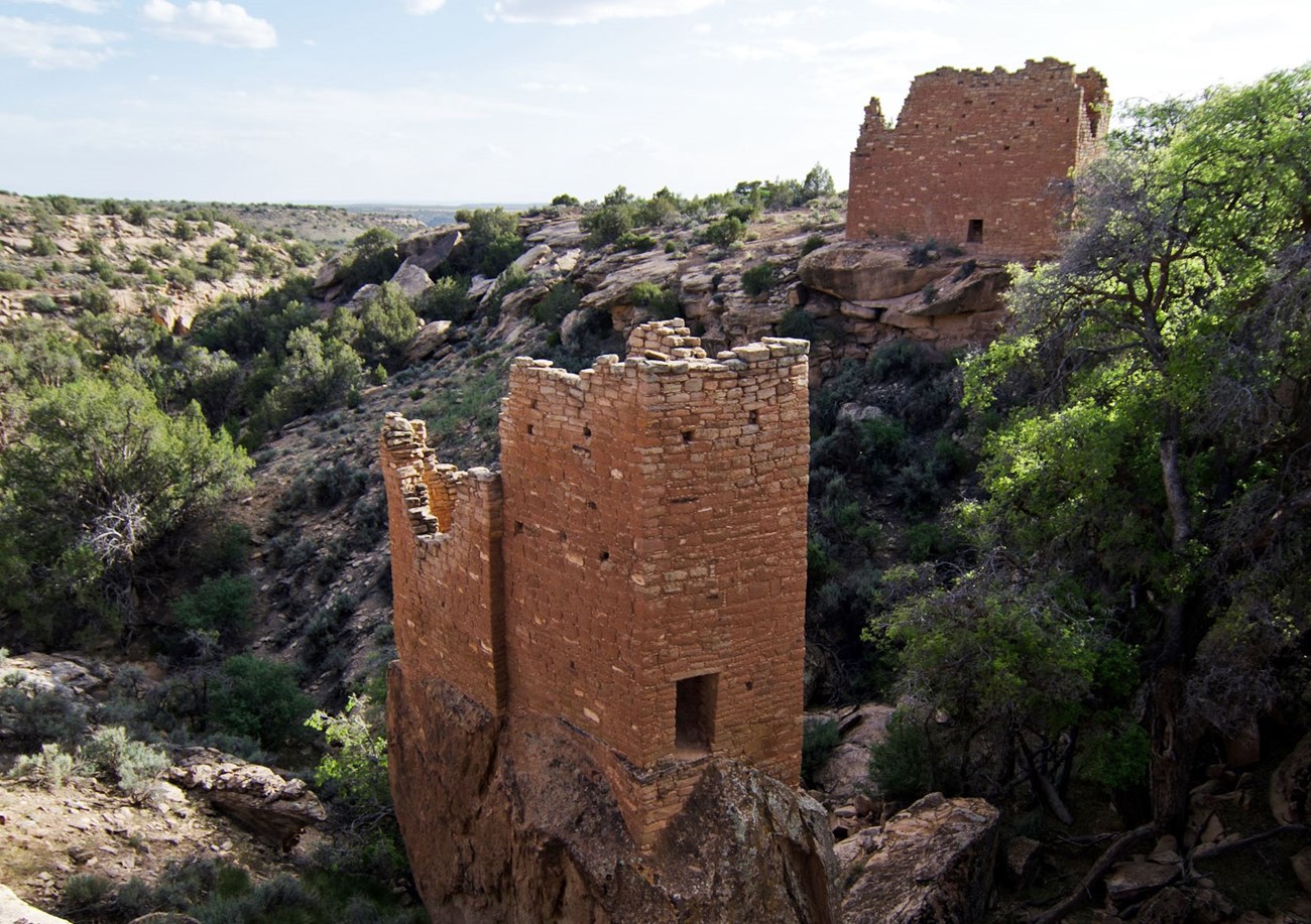 tall, rectangular stone structures perched on boulders and cliff edges