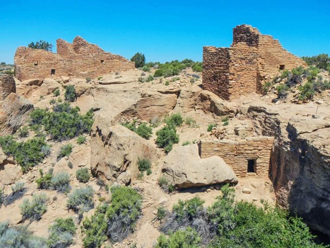 several stone structures built in and around a canyon