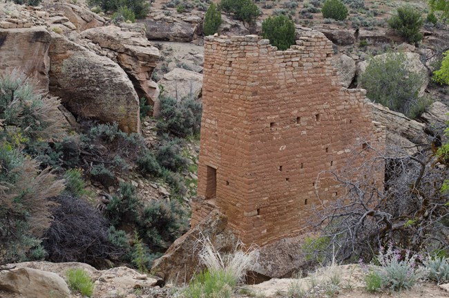 a tall stone tower atop a large boulder