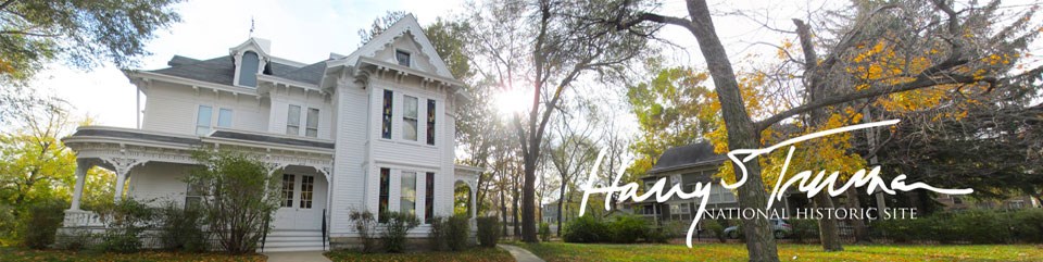 Front of a white home and yard with the words, "Harry S Truman National Historic Site."