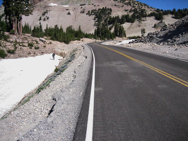 Person walking through snow along a highway at Lassen Volcanic National Park