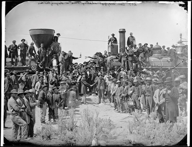 This 1869 photo shows the celebration at Promontory Summit where the transcontinental railroad was completed. Railroad workers and officials gathered between two locomotives for the Golden Spike ceremony