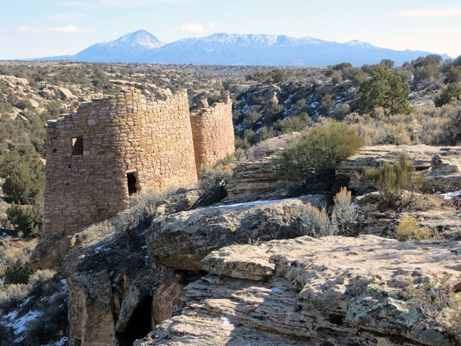 Round towers built on canyon edge, mountains in background